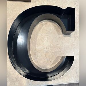 Metal “C” decor. Can be used to hold corks or anything else.